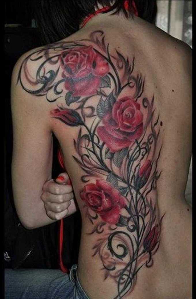 Крупная татуировка на полспины у девушки - красные розы среди черных стеблей
