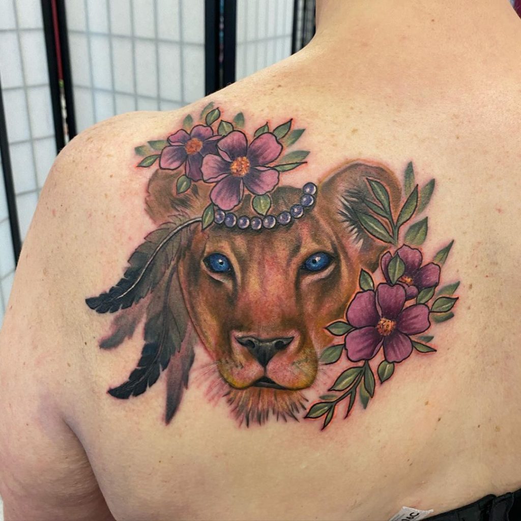Татуировка львицы в цветах на лопатке