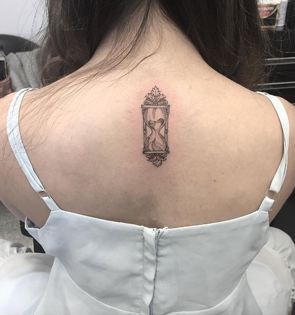 Tiny hourglass tattoo on back by Boomy