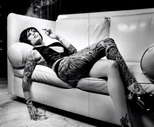 Девушка с татуировками на диване